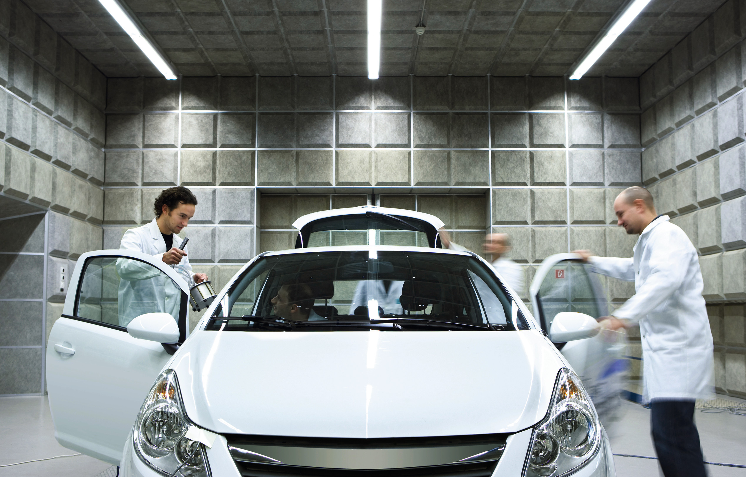 Autoneum technicians in noise test lab with Opel Corsa